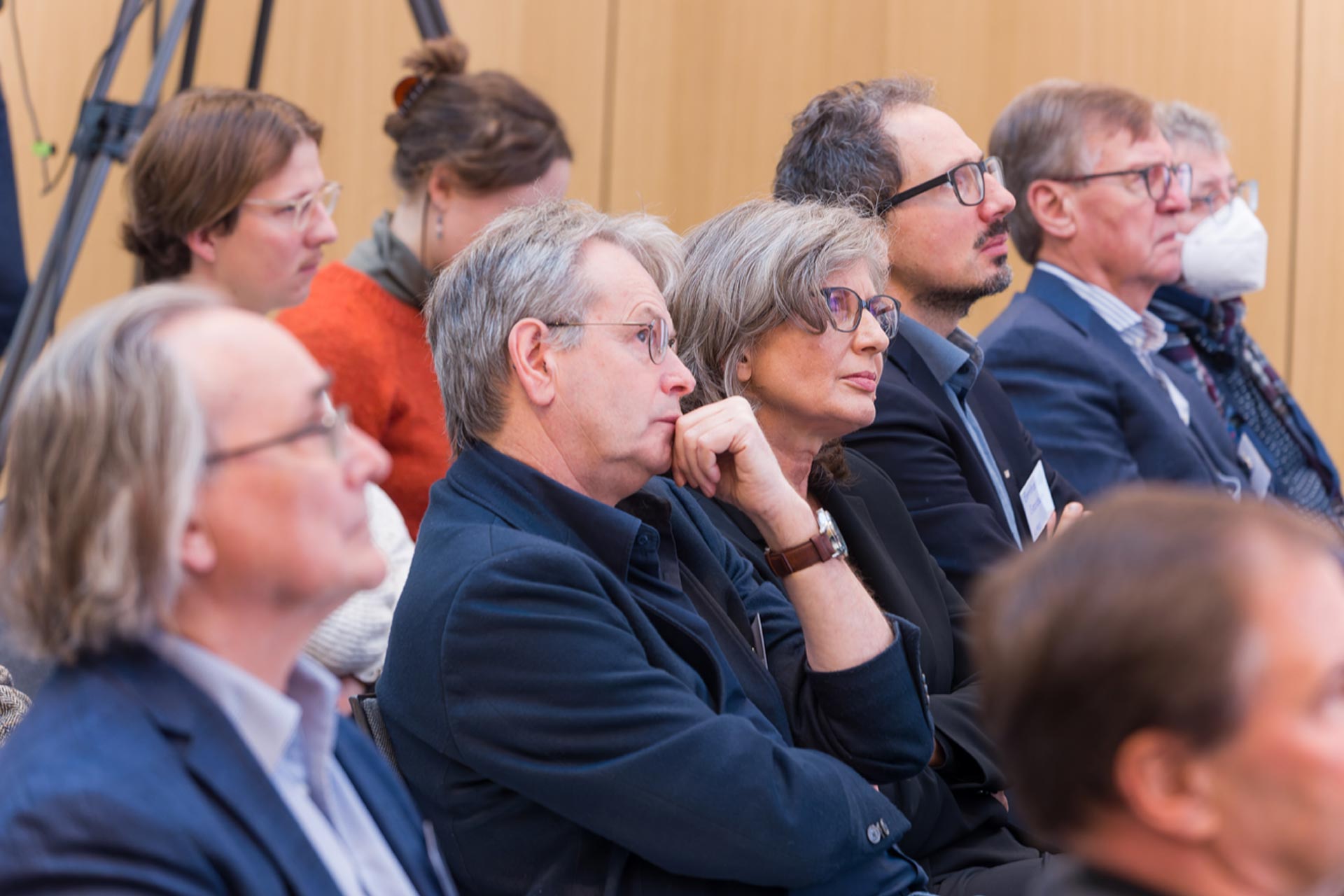 Einige Personen aus dem Publikum in Großaufnahme mit Blick zur Bühne.