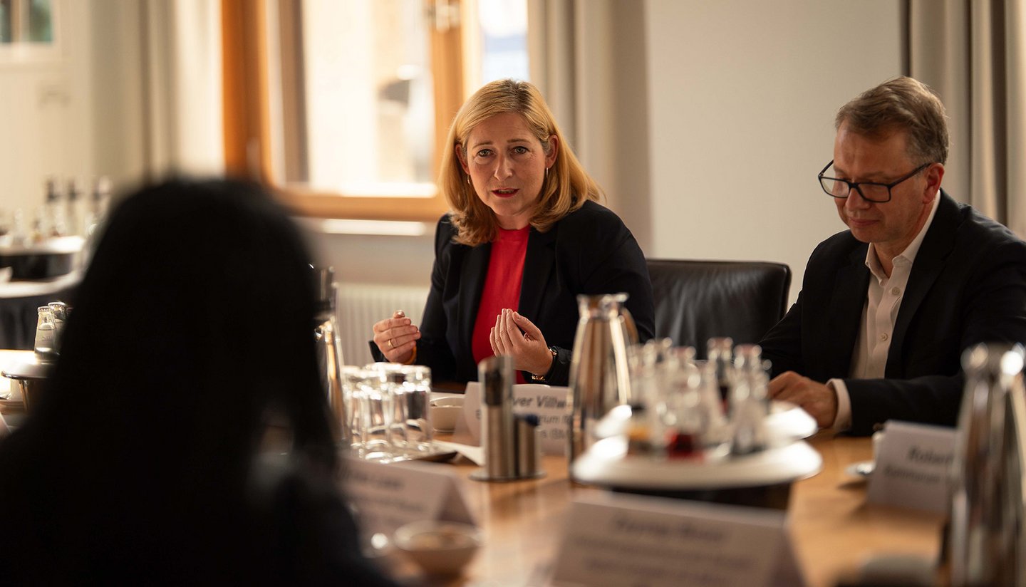Lilian Tschan spricht zu den weiteren Teilnehmenden am Konferenztisch. Im Fokus sind Lilian Tschan und Peer-Oliver Villwock.